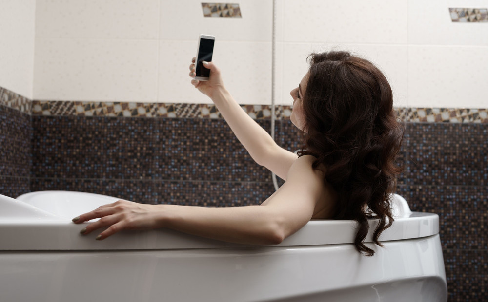 В ванной скрытая камера снимает ежедневно на видео красивую брюнетку с аппетитной фигурой