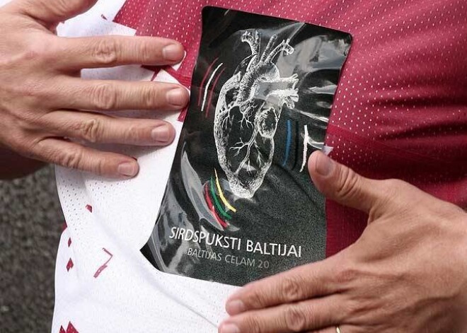 Pie sava tērpa Zatlers ar prieku līmēja akcijas „Sirdspuksti Baltijai” uzlīmi.