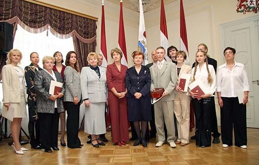 2005. gada 8. septembris. Toreizējā Valsts prezidente Vaira Vīķe-Freiberga, Naturalizācijas pārvaldes priekšniece Eiženija Aldermane un jaunie Latvijas pilsoņi, kuri svinīgajā pasākumā Rīgas pilī saņēma naturalizācijas dokumentus.