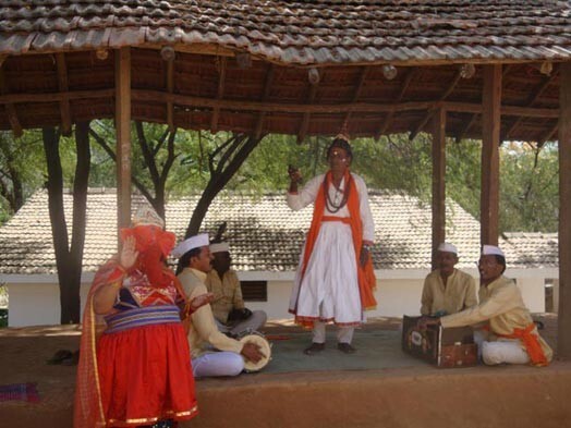 Reliģisks skečs ar dziedāšanu. Cilvēks sarkanajā tērpā attēlo hinduistu dievību Ganešu – šķēršļu pārvarētāju. Udaipurā jeb Baltajā pilsētā šādi skeči tiek uzvesti nepārtraukti.