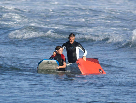 Deivids Behkems ar vecāko dēlu sērfo Malibu piekrastē ASV. Jau drīz ģimene kopā ar jaundzimušo meitiņu pārcelsies atpakaļ uz mājām Anglijā.