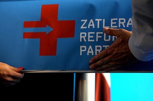 Zatlera Reformu partijas logotips ir medicīnisko palīdzību starptautiski simbolizējošais sarkanais krusts uz zila fona, un tajā iezīmēta no kreisās uz labo pusi vērsta bulta. Krusts simbolizē ārkārtas situāciju, kurā nepieciešama ārkārtas rīcība, skaidro ZRP pārstāvji.