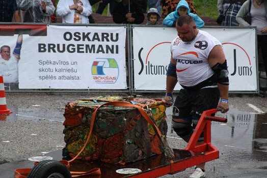 Latvijas spēcīgākais vīrs Agris Kazeļņiks, ķerru stumjot.