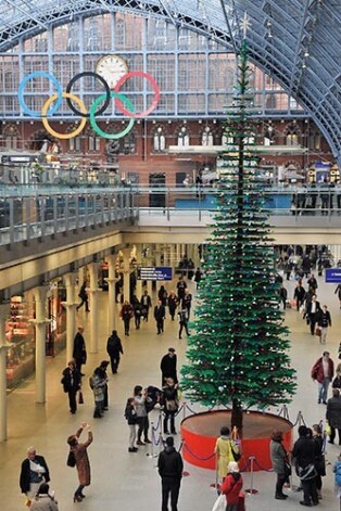 Vilcienu pasažieru Londonas Svētā Pankras stacijā pārsteidz milzīga svētku egle no lego klucīšiem.