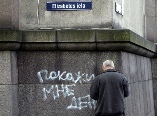 Uz valdības ēkas fasādes iepretim „Latvijas Krājbankas” reklāmai nakts melnumā kāds krievu valodā uzkrāsoja lūgumu parādīt viņam naudu.