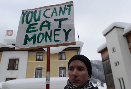 Protestants, turot rokās plakātu: „You can’t eat money” (no angļu valodas: „Jūs nedrīkstat ēst naudu”).