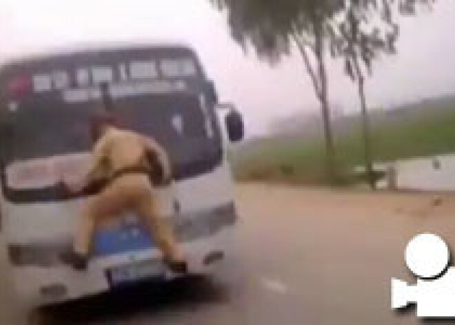 Fanātisks policists uz braucoša autobusa vējstikla. VIDEO