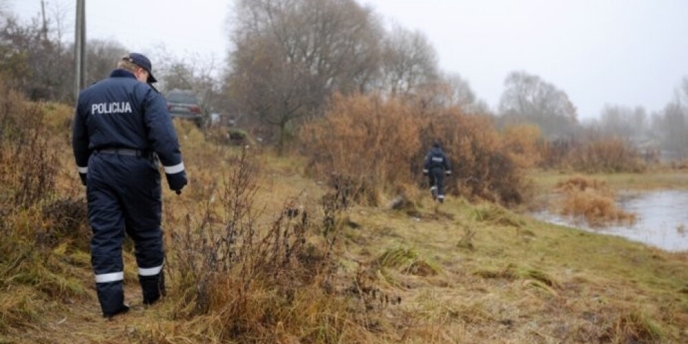 Работники полиции осматривают берег Даугавы в поисках браконьерских сетей