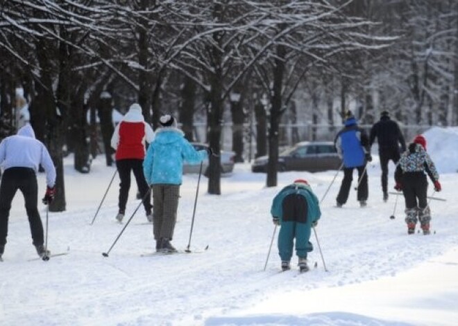 Vecāki ar bērniem Rīgas ziemas parkos  izbauda ziemas priekus. FOTO