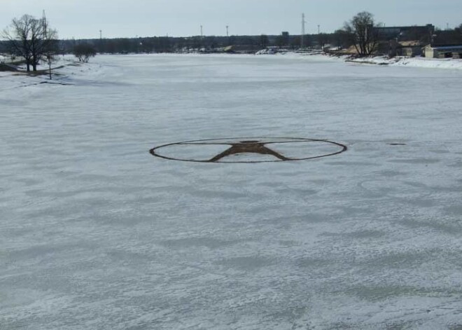 „Saskaņiešu” fani kāpj uz ledus, lai zīmētu logo. FOTO