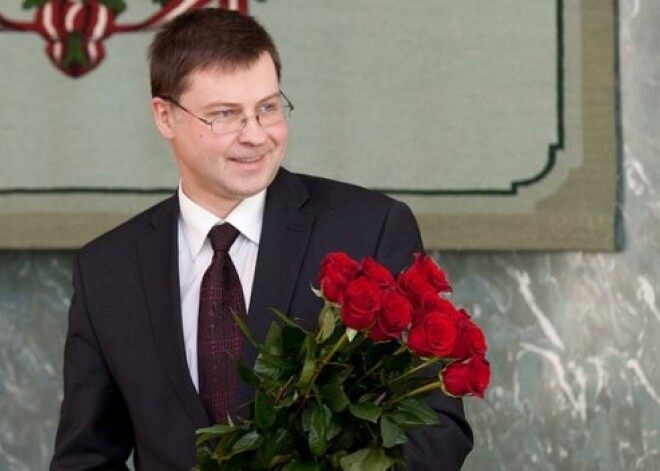 Premjeru Dombrovski sveic ar sarkanu rožu pušķi. Viņš smaida! FOTO