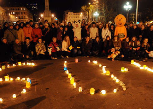 Cilvēki noliek svecītes pie Brīvības pieminekļa akcijas "Zemes stundas" laikā 2011. gadā.