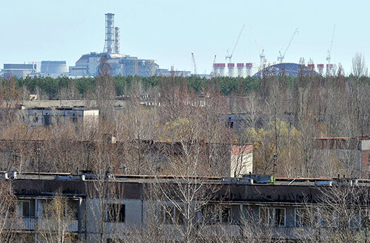 Так сейчас выглядит печально знаменитый город-призрак Припять, который навсегда вымер после катастрофы на Чернобыльской АЭС. Вдали - купол, закрывающий четвертый энергоблок