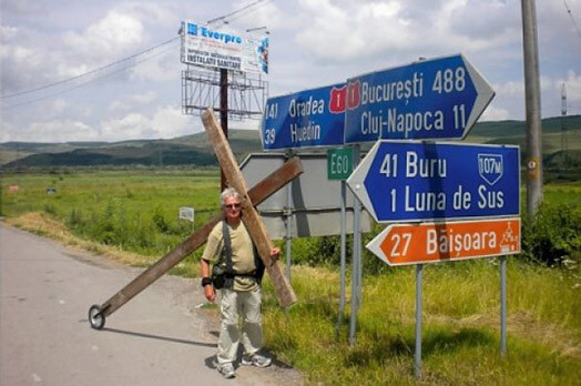 Nebrīnieties, ja šajās dienās uz Latgales šosejas sastopaties ar vīru, kurš stiepj milzīgu koka krustu, - tas ir kristīgais misionārs Lindsija Hamons. Attēlā: Hamons krustu nes pa Rumānijas ceļiem.