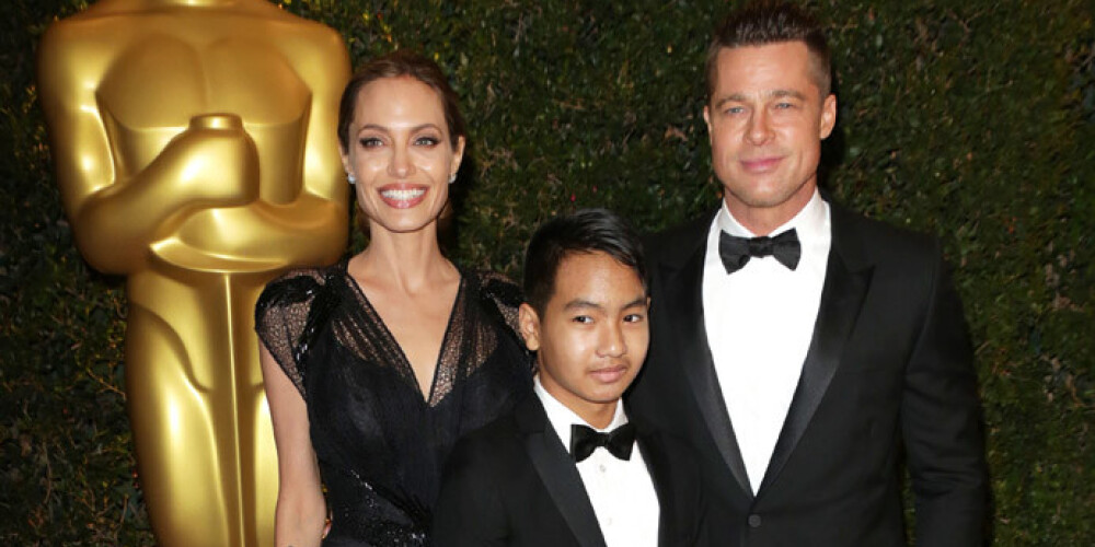 Актриса Анджелина Джоли со спутником жизни Брэдом Питтом и их приемным сыном Мэддоксом на красной дорожке