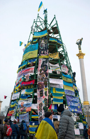 Ukrainas galvaspilsētas centrālajā laukumā Kresčatikā politisko protestu dēļ galvenās egles uzstādīšana tā arī palikusi pusratā. Tagad tās karkasu ar Ukrainas karogiem un palakāties, kas pieprasa Ukrainas eirointegrāciju. izrotājuši prezidenta Viktora Janukoviča opozicionāri.