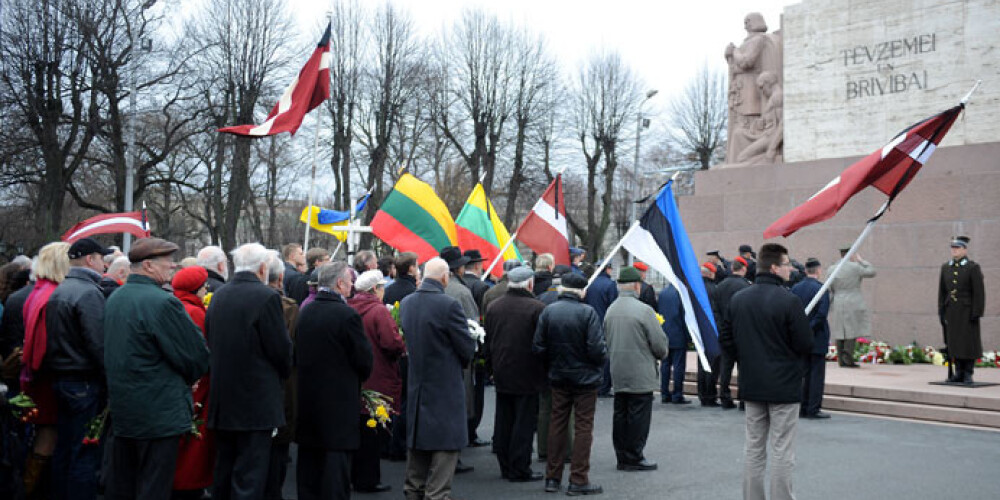 Gājiena dalībnieki turēja rokās Latvijas, Lietuvas, Igaunijas un Ukrainas karogus ar sēru lentēm.