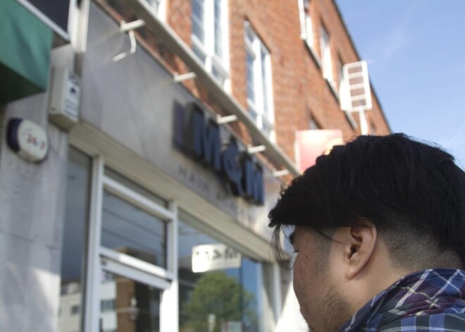 Frizētava Londonā kuras reklāmas plakātā redzams Ziemeļkorejas diktators Kims Čenuns