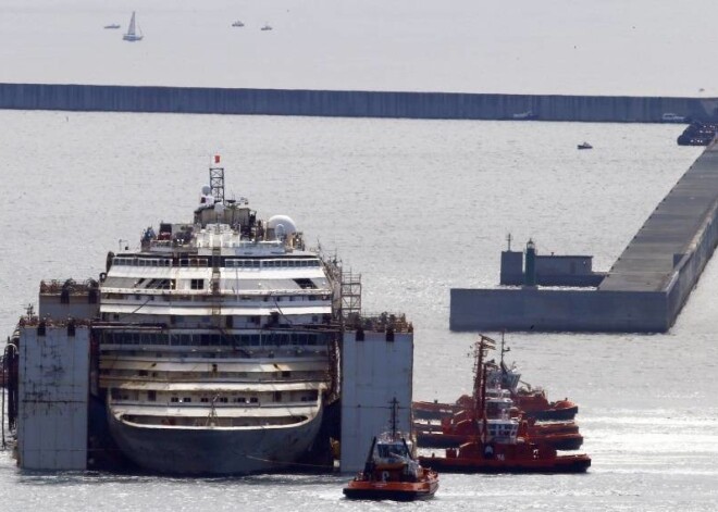 Jau ziņots, ka " Costa  Concordia" trešdien devās savā pēdējā jūras ceļojumā, kad velkoņi sāka reiz luksusa braucienus piedāvājušā kuģa nogādāšanu no avārijas vietas pie Džiljo salas krastiem, kur tas pavadījis divarpus gadus, uz Dženovas ostu Itālijas ziemeļrietumos, kur tas tiks sagriezts metāllūžņosRūsējošais kuģis, kas izmēra ziņā divas reizes pārsniedz bēdīgi slaveno "Titāniku", ir novietots uz milzīgām saspiesta gaisa kamerām, kas to notur virs ūdens un atvieglo velkoņu darbu.