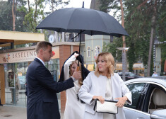 SIA „Domenikss” valdes priekšsēdētāja Benita Sadauska tika slēpta zem lietussarga, lai lietus nesabojātu skaisto frizūru un grimu.