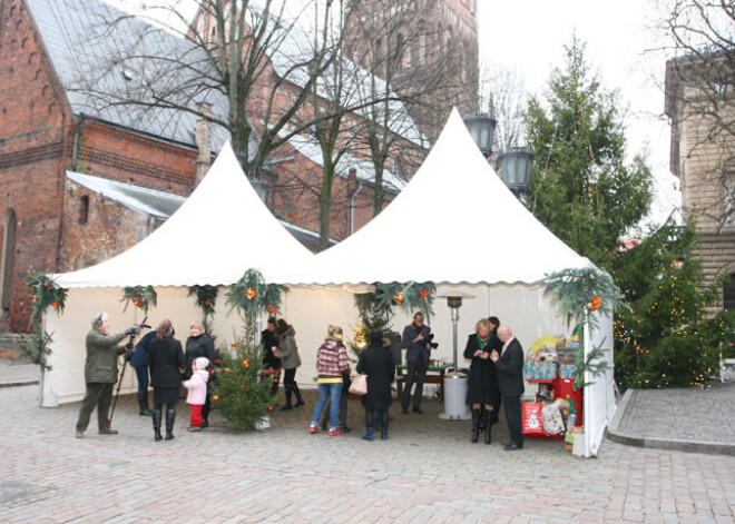 Pie Saeimas nama deputāti iesaiņo Ziemassvētku dāvanas bērniem. FOTO