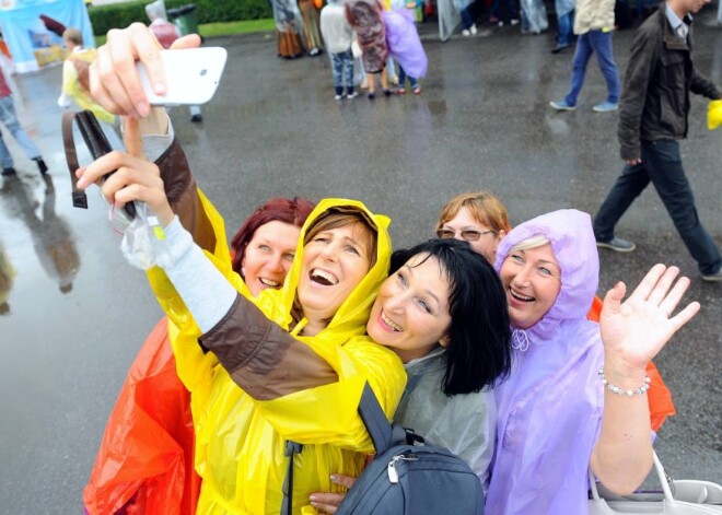 Dalībnieki un apmeklētāji pirms deju lielkoncerta "Līdz varavīksnei tikt" Daugavas stadionā