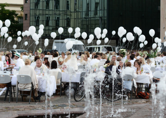 Ļaudis baltā sarīko pikniku pie Kongresu nama. FOTO