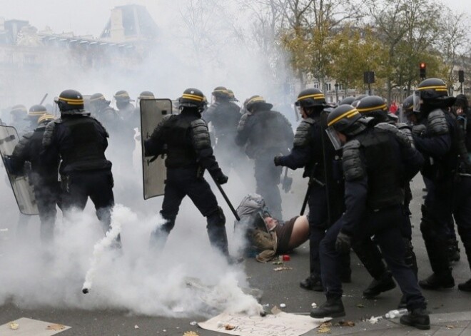 Parīzē policija pret agresīviem klimata aktīvistiem pielieto asaru gāzi. FOTO