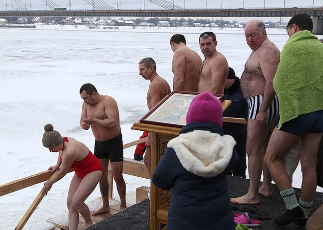 Blakus peldot ledus gabaliem, pareizticīgie Rīgā gremdējas Daugavā. FOTO