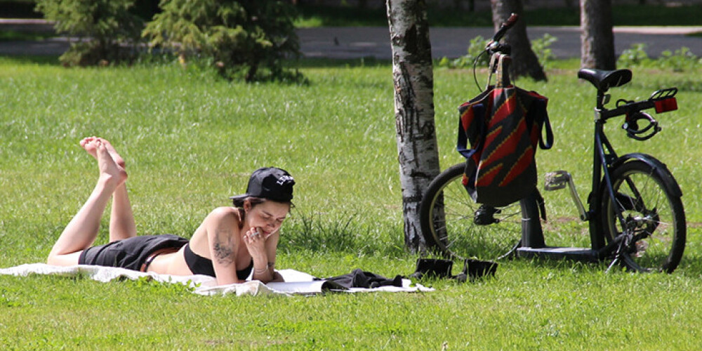 Agnese Kleina parkā lasa visu pēc kārtas un sauļo pēdiņas