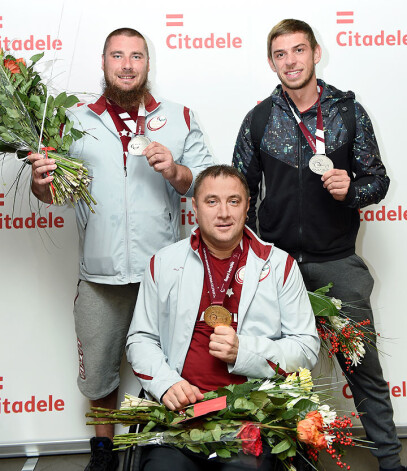 Paralimpiskie vieglatlēti - Edgars Bergs ar sudraba medaļu lodes grūšanā (no kreisās), Aigars Apinis ar zelta medaļu diska mešanā un Dmitrijs Silovs ar sudraba medaļu šķēpmešanā, atgriežoties no Katarā notikušā Pasaules čempionāta vieglatlētikā 2015. gadā.