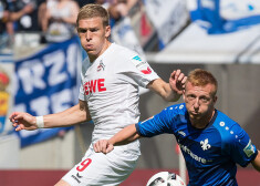 Rudņevs (pa kreisi) "Koln" kluba krāsās cīņā par bumbu.