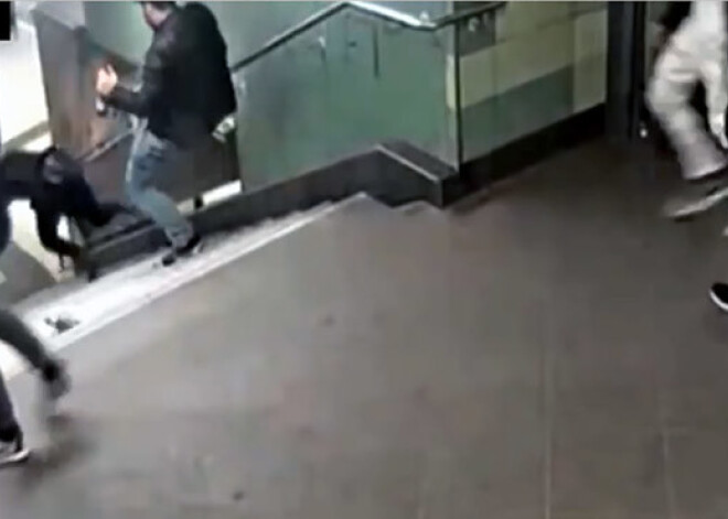 Sadzērusies banda Vācijas metro iesper sievietei, kura nokūleņo pa trepēm. VIDEO