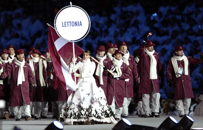 Turīnas Olimpiskajās spēlēs Artūrs Irbe ieved Latvijas izlasi un nes sarkanbaltsarkano karogu.