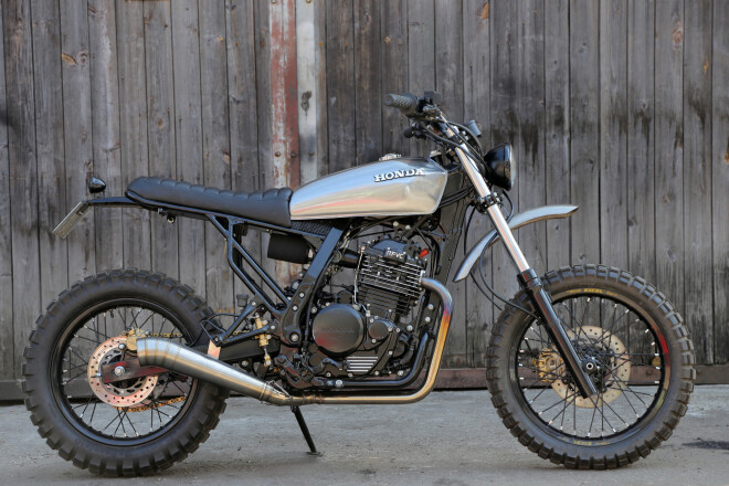 Uzmanību, skremblers! Tā dēvēja agrīnos krosa motociklus, kas būtība bija bezceļa braukšanai piemēroti standartnieki. Šis eksemplārs uzbūvēts, par pamatu ņemot Honda NX650 Dominator, ko ražoja no 1988. līdz 2011. gadam.