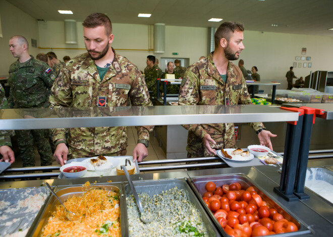 No padomju laikiem daļā sabiedrības varētu būt nostiprinājies uzskats, ka dienējošs karavīrs ēd ļoti pieticīgi. Taču Ādažu militārās bāzes apjomīgā un modernā ēdnīca liecina, ka tie laiki jau sen ir garām. Kā ciemošanās laikā noskaidroja Kasjauns.lv komanda, gan mūsu pašu, gan arī sabiedroto valstu karavīrus šeit itin labi pabaro.