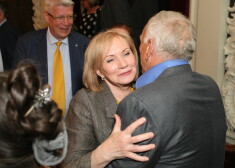 Eksprezidents Valdis Zatlers tik pārsteigts noskatās, kā filmas pirmizrādē nesen dažas dienas izolatorā nosēdējušais miljonārs Jūlijs Krūmiņš skauj bijušo pirmo lēdiju Lilitu Zatleri.