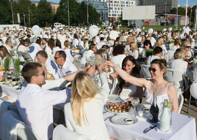 Eleganti ļaudis baltās drēbēs sarīko pikniku Rīgas pasažieru ostā