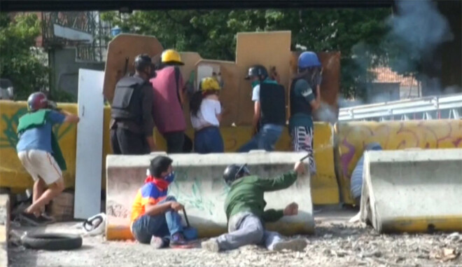 Cilvēki protestē pret Venecuēlas prezidentu Nikolasu Maduro.