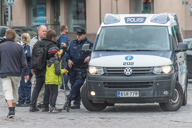 Policists Turku tirgus apkārtnē runā ar cilvēkiem.