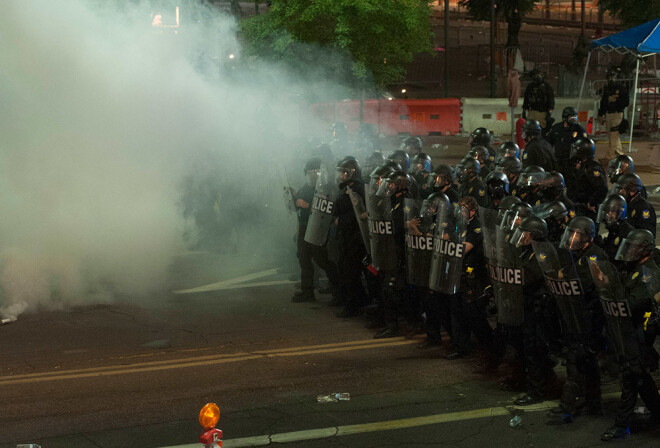 Policija ar asaru gāzes palīdzību mēģina savaldīt protestētājus.