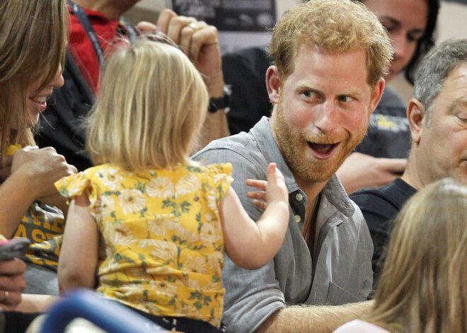 Princis Harijs amzierējas ar divgadīgu meitenīti, vērojot kara veterānu – invalīdu sporta spēles Invictus Games Toronto Kanādā, 2017. gada 27. septembrī.