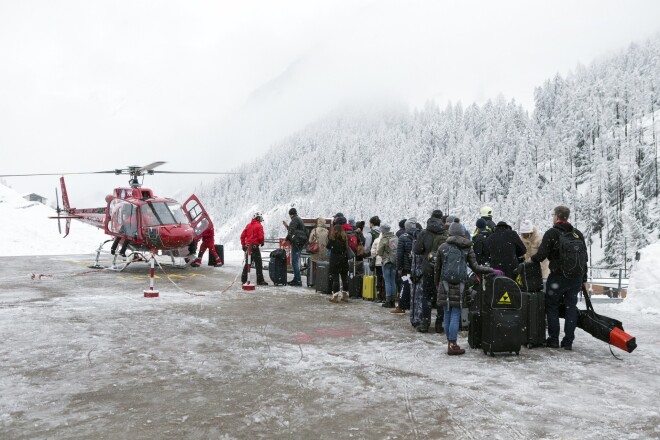 Tūrsti gaida rindā uz helikopteru, kas viņus evakuē no Cermates slēpošanas kūrorta.