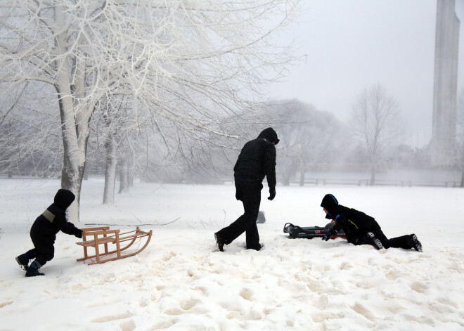 Foto: Beidzot! Cilvēki Uzvaras parkā bauda ziemas priekus