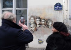 TOPSHOT - A man takes a picture of portraits (LtoR) of late French satirical weekly Charlie Hebdo's deputy chief editor Bernard Maris, French cartoonists Georges Wolinski, Bernard Verlhac (aka Tignous), Charlie Hebdo editor Stephane Charbonnier (aka Charb) and Jean Cabut (aka Cabu) near the magazine's offices at Rue Nicolas Appert, in Paris on January 7, 2018, on the third anniversary of the jihadist attack on French satirical magazine Charlie Hebdo.
Two French jihadists who had sworn allegiance to al-Qaeda killed 11 people at Charlie Hebdo's offices in 2015 over the staunchly atheist magazine's satirical coverage of Islam and the prophet Mohammed. / AFP PHOTO / CHRISTOPHE ARCHAMBAULT