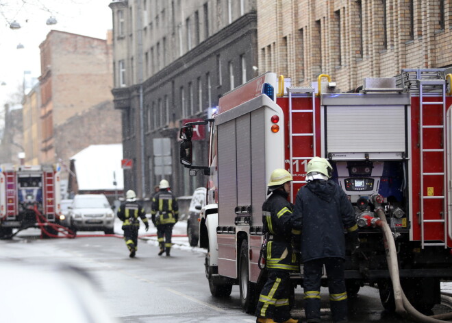 Foto: daudzstāvu ēkā Rīgas centrā izcēlies ugunsgrēks