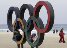 epa06541999 Tourists posing for photos sit inside the Olympic rings at Gyeongpo beach near the Olympic village in Gangneung, South Korea, 19 February 2018.  EPA/VALDRIN XHEMAJ