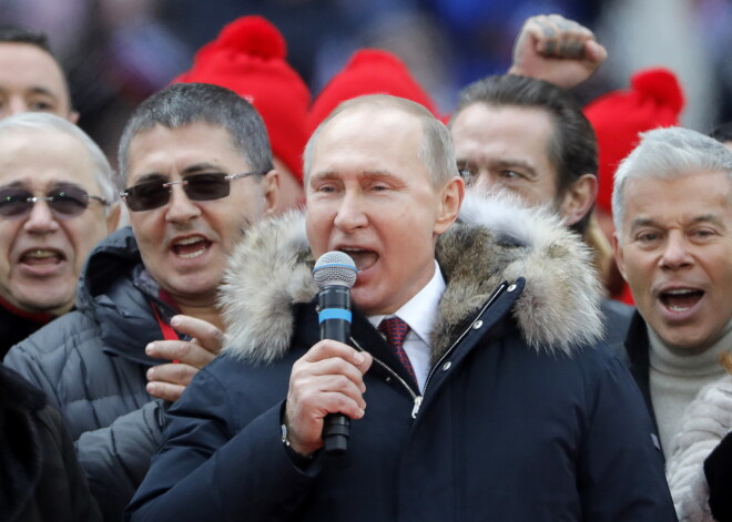 Фоторепортаж: Путин спел гимн России на митинге в поддержку своей кандидатуры