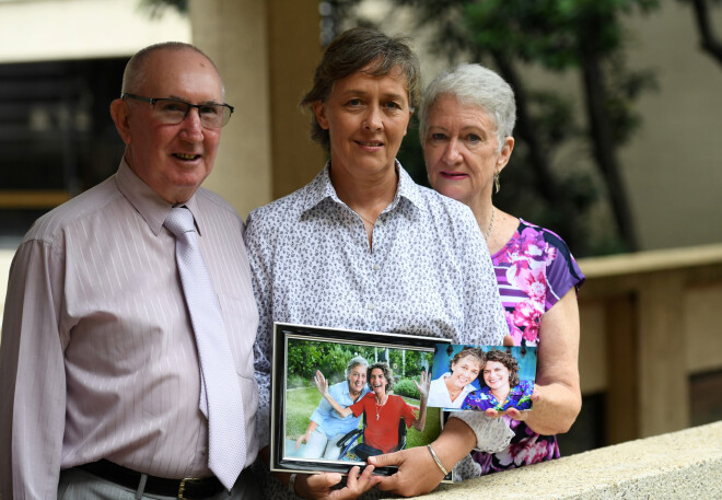 Atraitne rokās tur foto ar savu mirušo sievu; viņu atbalsta mirušās māte Sandra un tēvs Pauls.