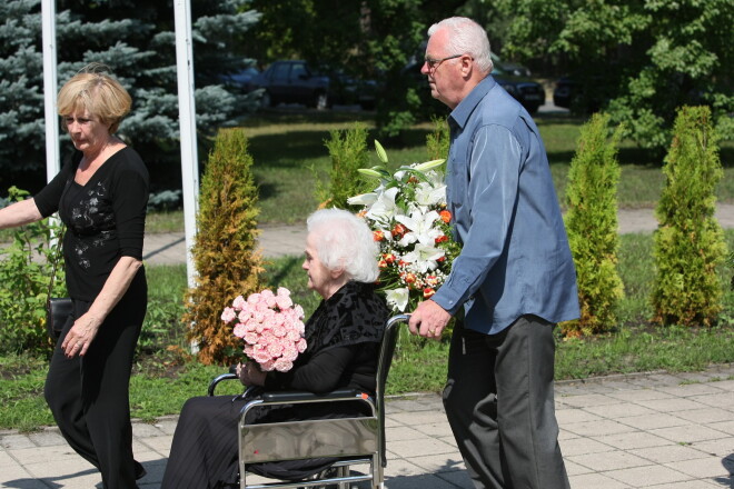 Marga Lībere (ratiņkrēslā) Intas bērēs, kuras organizēja un uz kurām palīdzēja saposties tobrīd aprūpētāja un draudzene Māra Kalniņa ar dzīvesbiedru.